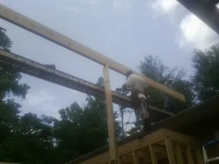 Carpenter setting a ridge beam over a new addition frame — Ice Dam Removal by Roofing Brothers in Wilsonville