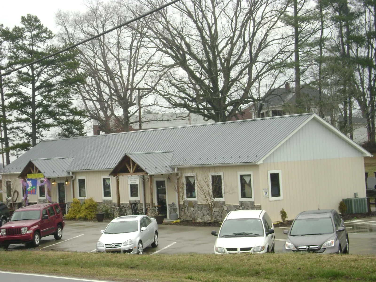 Gray metal roof with timber entry brackets on a small commercial building in Wilsonville